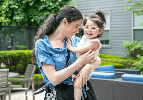 Kim holds her daughter, Isabella, who is smiling.